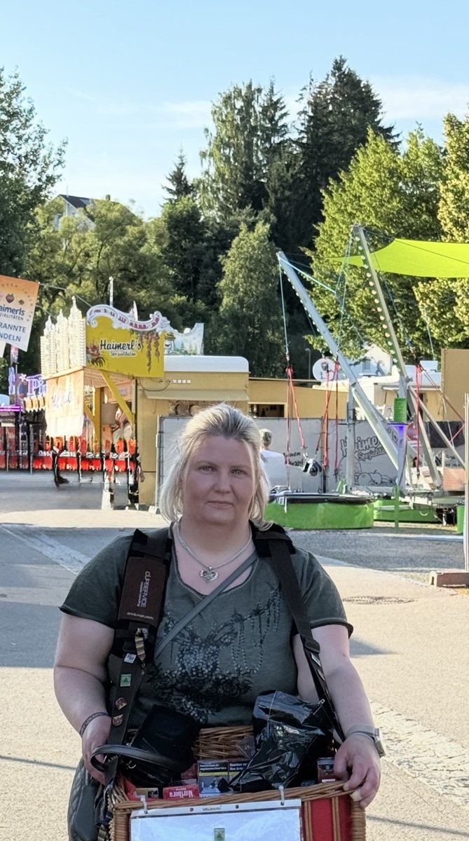 Beate mit Bauchladen auf dem Festplatz des Grenzlandfests am fr&uuml;hen Abend