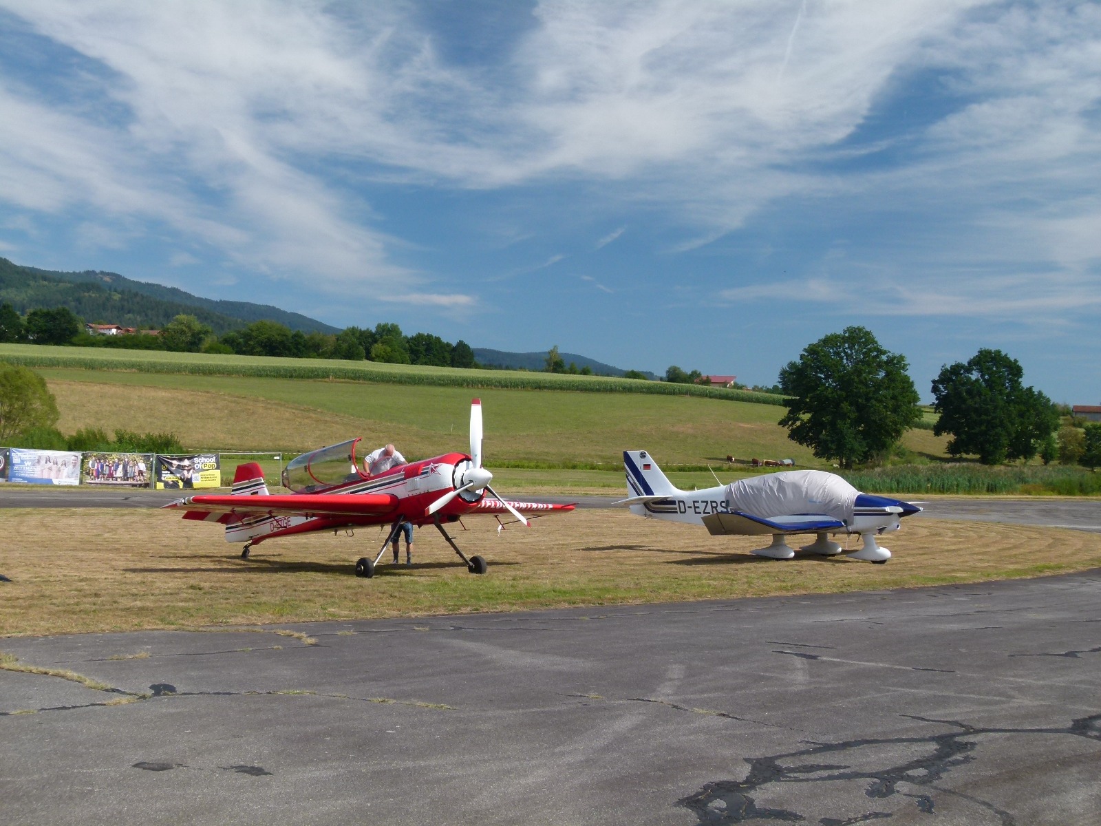 Ein roter Kunstflieger und eine Robin DR400 auf dem Vorfeld in Arnbruck